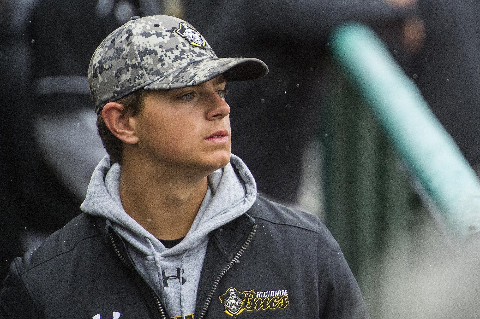 An Anchorage Bucs baseball player watches the Military Appreciation Game pregame ceremonies at Mulcahy Stadium in Anchorage, Alaska, June 19, 2016. (U.S. Air Force photo by Senior Airman James Richardson/Released)