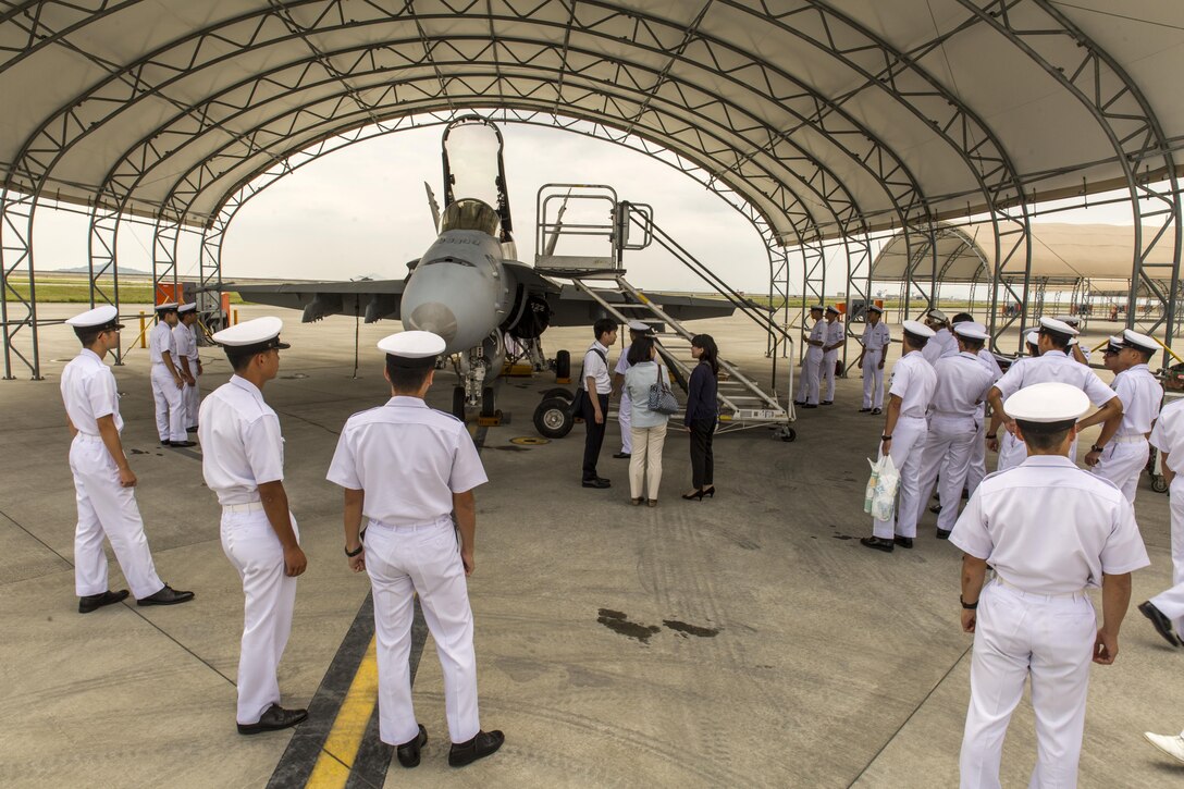 Japan Air Self-Defense Force aviation officer cadets from the Japan Maritime Self-Defense Force Ozuki Aviation Training Squadron observe an F/A-18C static display during a Japanese Officer Exchange Program tour at Marine Corps Air Station Iwakuni, Japan, June 17, 2016. Hosted by Marine Aircraft Group 12, the exchange program aims to better the understanding and working relationships between U.S. and Japanese pilots. (U.S. Marine Corps photo by Lance Cpl. Aaron Henson/Released)