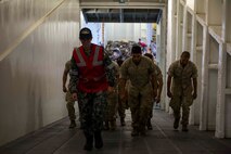 An Australian sailor guides U.S. Marines to an upper deck aboard the HMAS Adelaide at Port of Brisbane, Queensland, Australia, June 16, 2016. This marks the first time Marines and sailors from Marine Rotational Force - Darwin have embarked in such numbers on an Australian HMAS. This opportunity allows for MRF-D to expand the partnership capabilities with our Australian allies. The Marines are with 1st Battalion, 1st Marine Regiment, MRF-D, and the Australians are with HMAS Adelaide.