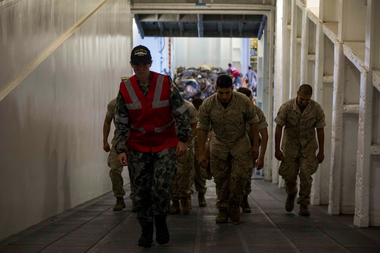 An Australian sailor guides U.S. Marines to an upper deck aboard the HMAS Adelaide at Port of Brisbane, Queensland, Australia, June 16, 2016. This marks the first time Marines and sailors from Marine Rotational Force - Darwin have embarked in such numbers on an Australian HMAS. This opportunity allows for MRF-D to expand the partnership capabilities with our Australian allies. The Marines are with 1st Battalion, 1st Marine Regiment, MRF-D, and the Australians are with HMAS Adelaide.
