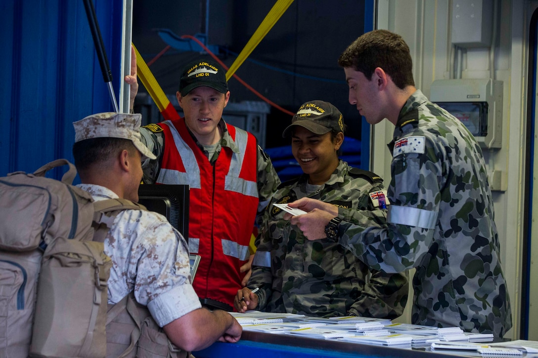 U.S. Marines receive a welcome aboard booklet upon arrival to the HMAS Adelaide at Port of Brisbane, Queensland, Australia, June 16, 2016. This marks the first time Marines and sailors from Marine Rotational Force - Darwin have embarked in such numbers on an Australian HMAS. This opportunity allows for MRF-D to expand the partnership capabilities with our Australian allies. The Marines are with 1st Battalion, 1st Marine Regiment, MRF-D, and the Australians are with HMAS Adelaide.