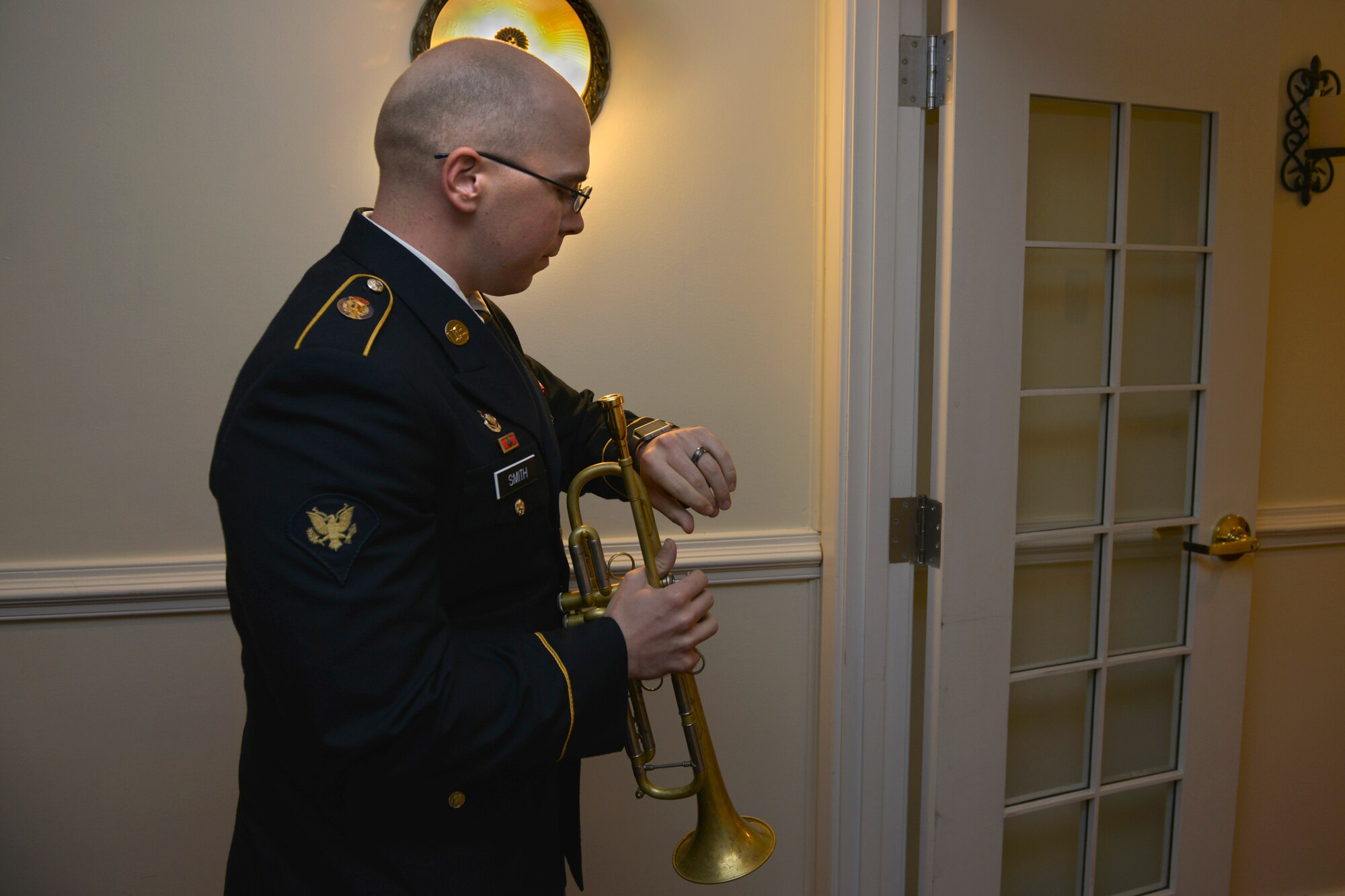 U.S. Army Spc. Peter Smith, U.S. Army Training and Doctrine Band brass instrumentalist, checks the time before playing the bugle to announce dinner during the Army Ball at Fort Eustis, Va., June 17, 2016. This year’s ball celebrated the Army’s 241st birthday with a streamer ceremony, historical photo slide show and a guest speaker.  (U.S. Air Force photo by Staff Sgt. Natasha Stannard)