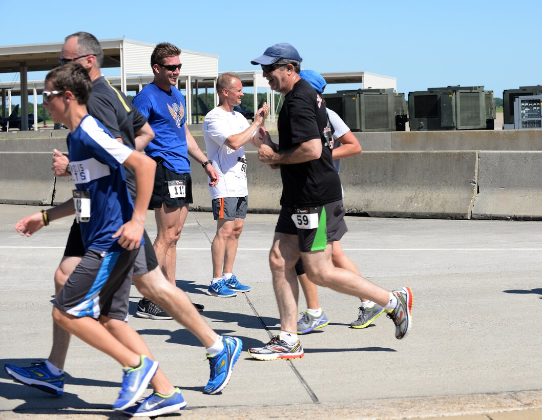 Tyler Johnson, Langley Chapter Air Force Association president, and U.S. Air Force Chief Master Sgt. Mark Hurst, 633rd Air Base Wing command chief, cheer for runners during the AFA Wounded Airman Program 5K at Langley Air Force Base, Va., June 18, 2016. According to Johnson, all the proceeds from the run will go toward supporting wounded Air Force veterans. (U.S. Air Force photo by Staff Sgt. Teresa J. Cleveland)