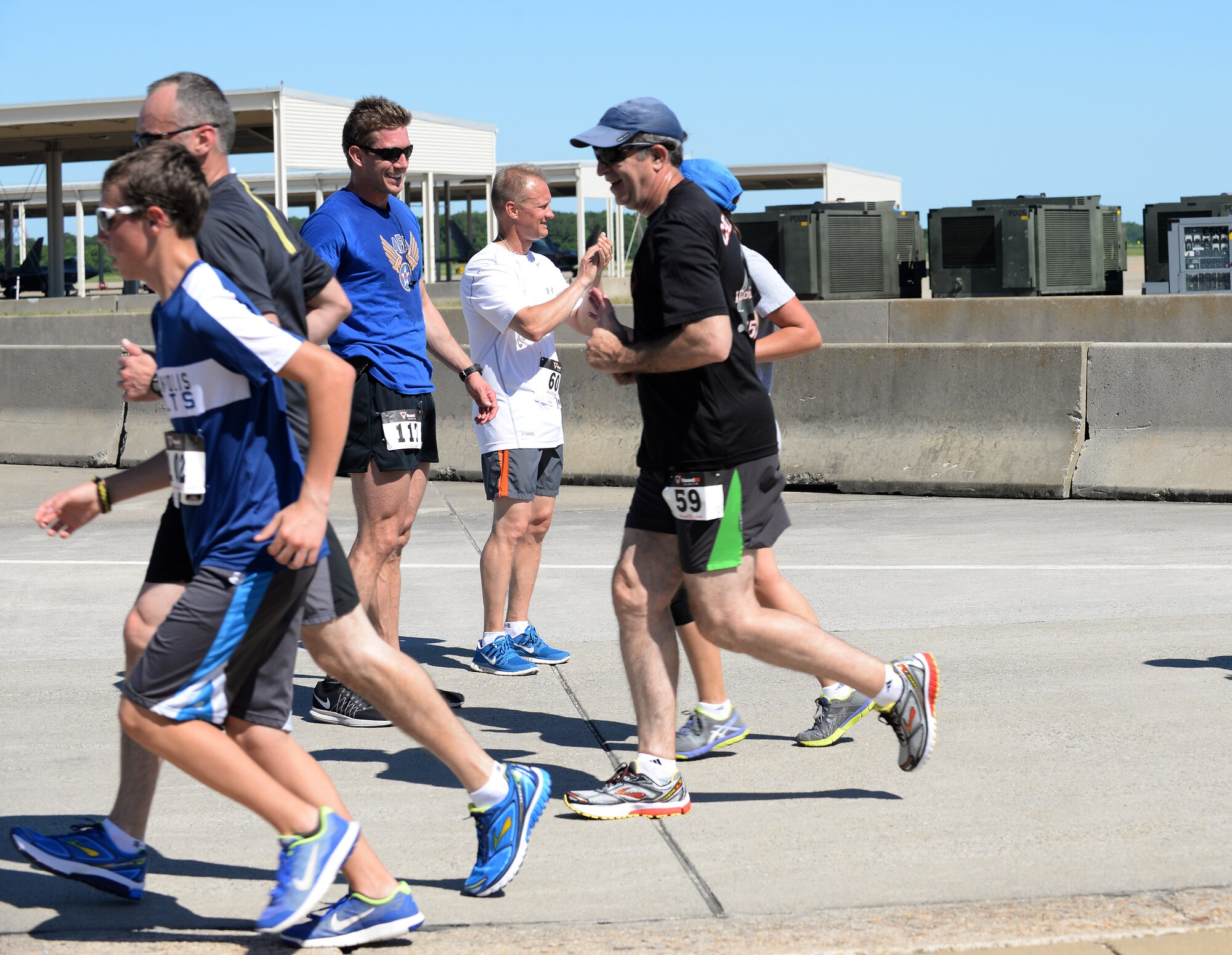 Tyler Johnson, Langley Chapter Air Force Association president, and U.S. Air Force Chief Master Sgt. Mark Hurst, 633rd Air Base Wing command chief, cheer for runners during the AFA Wounded Airman Program 5K at Langley Air Force Base, Va., June 18, 2016. According to Johnson, all the proceeds from the run will go toward supporting wounded Air Force veterans. (U.S. Air Force photo by Staff Sgt. Teresa J. Cleveland)