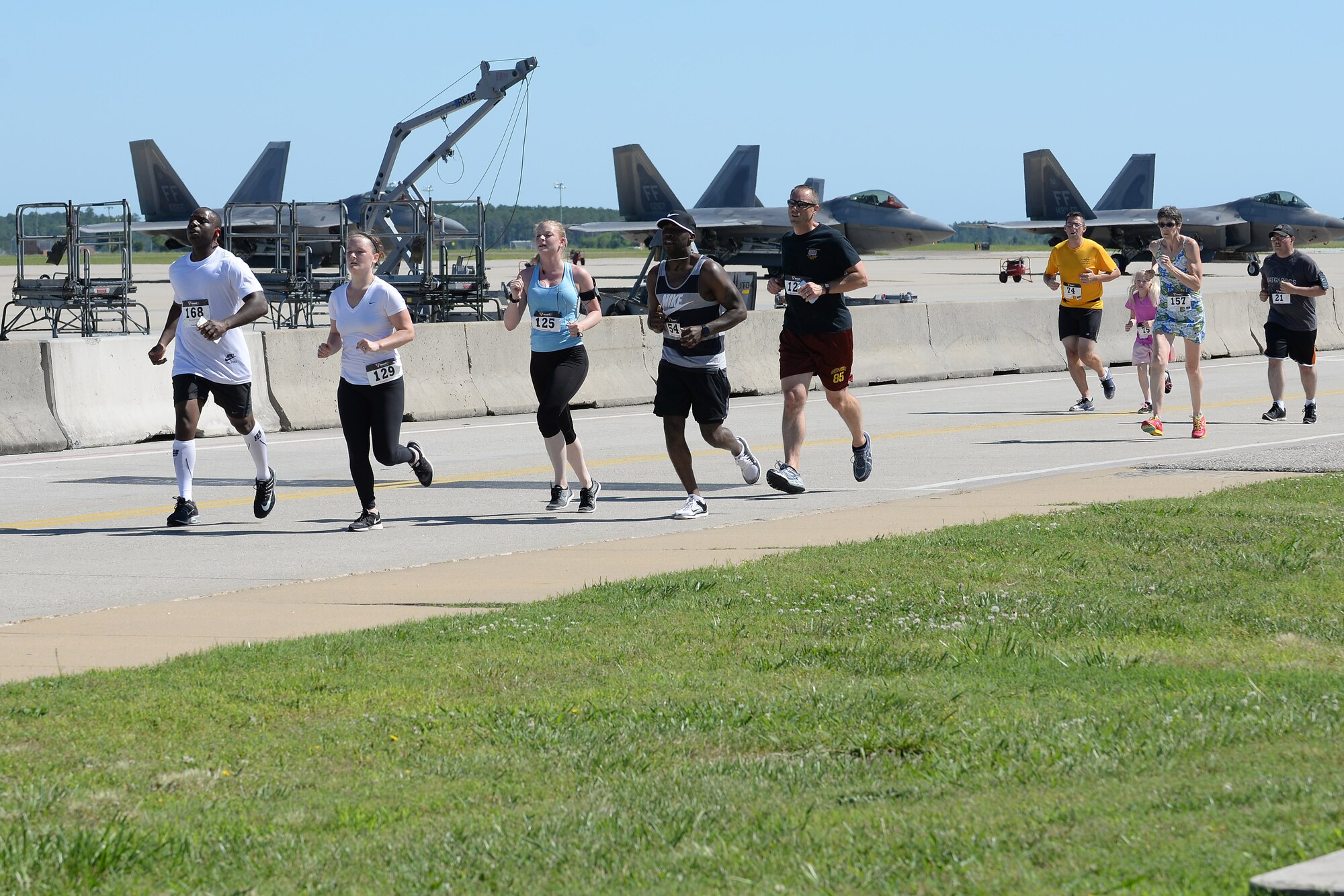 Runners cross the flight line during the Langley Chapter Air Force Association Wounded Airman Program 5K at Langley Air Force Base, Va., June 18, 2016. The run began near the 1st Fighter Wing Headquarters, then followed the running trail past some of the oldest houses on the installation and across the flight line. (U.S. Air Force photo by Staff Sgt. Teresa J. Cleveland)