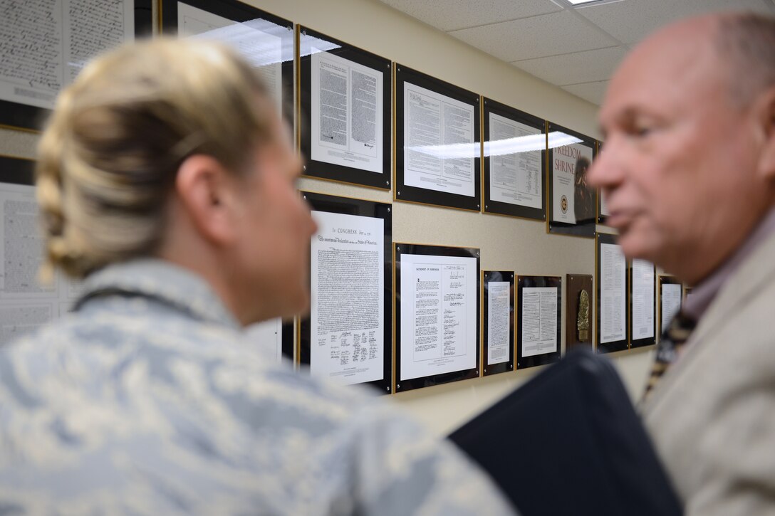 U.S. Air Force Col. Caroline Miller, 633rd Air Base Wing commander, and William Trimble, National Exchange Club Region 11 vice president, discuss documents hanging on the wall at the Professional Development Center that make up the Freedom Shrine at Langley Air Force Base, Va., June 14, 2016. The NEC dedicated the documents, known as a Freedom Shrine, which serve as an educational tool in schools and as a motivational display in public arenas. (U.S. Air Force photo by Staff Sgt. Teresa J. Cleveland)