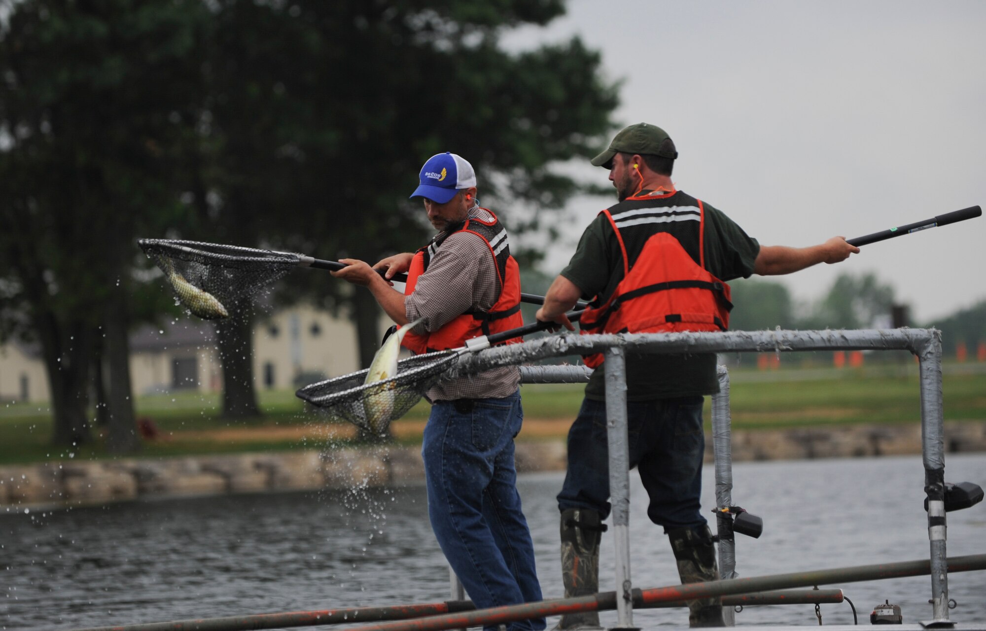 Keith Donaldson, left, a natural resource manager assigned to the 509th Civil Engineer Squadron, and Ty Cravens, right, a resource assistant with the Missouri Department of Conservation, collect fish from Ike Skelton Lake at Whiteman Air Force Base, Mo., June 21, 2016. From the data they collected, the team determined which fish needed to be added to the lake to balance out the ecosystem. (U.S. Air Force photo by Senior Airman Danielle Quilla)