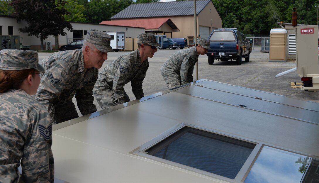 Members from the 157th Civil Engineering Squadron assist with taking down a wall in the FORTS (Fold-Out Rigid Temporary Shelters) structure at Pease Air National Guard Base, N.H., June 17.  The FORTS structure can be set up in less than 10 minutes, and are designed to withstand wind loads of over 100mph. (U.S. Air National Guard photo by Tech. Sgt. Erica Rowe)