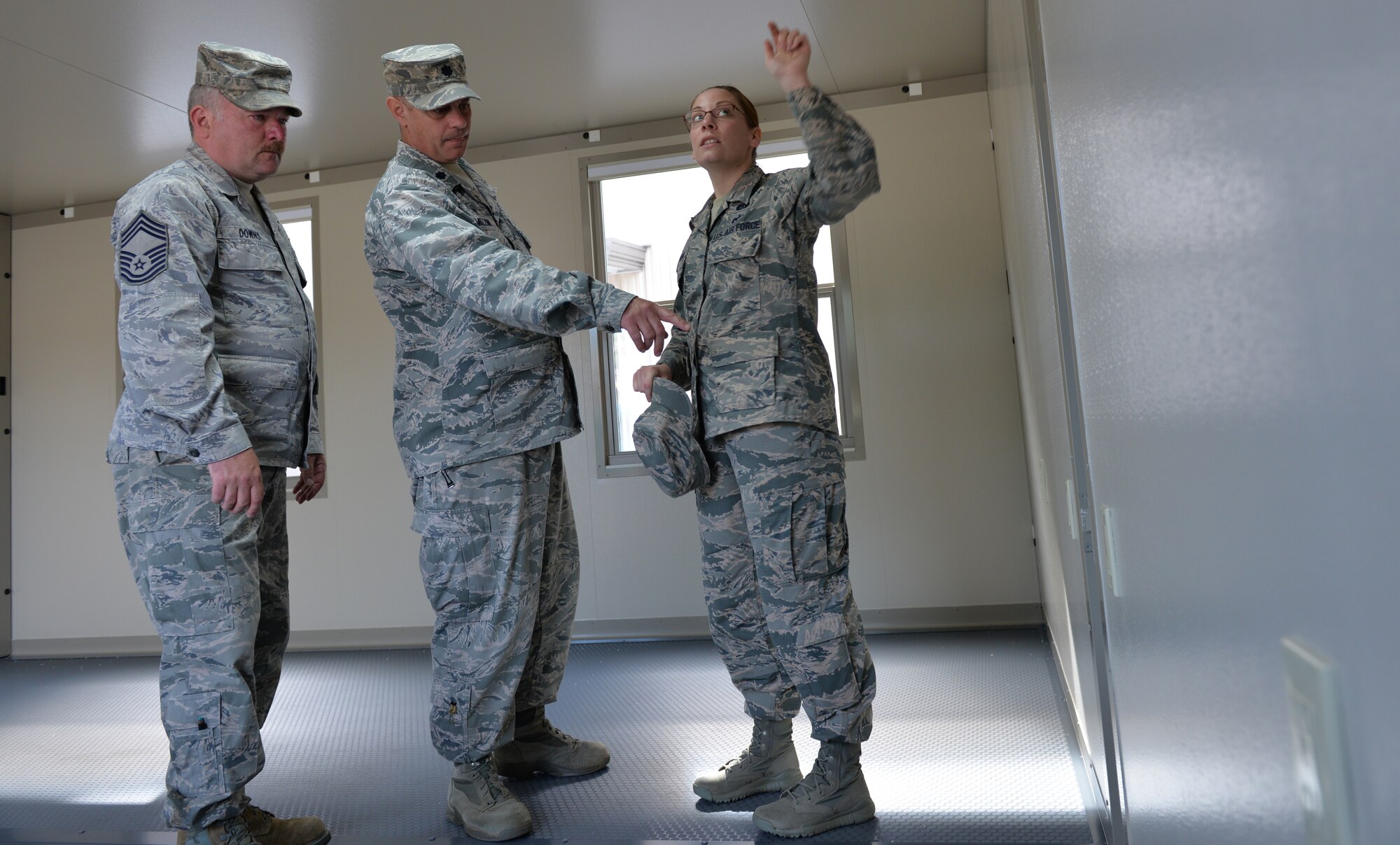 Chief Master Sgt. Keith Downs, 157th Civil Engineering Squadron emergency management manager, Lt. Col. Eugene Mozzoni, 157 CES commander, and Tech. Sgt. Sophia Inman, 157 CES emergency management craftsman, point to various amenities located within the FORTS (Fold-Out Rigid Temporary Shelters) structure at Pease Air National Guard Base, N.H., June 17.  The FORTS structure include electrical outlets, air conditioning, and data connections. (U.S. Air National Guard photo by Tech. Sgt. Erica Rowe)