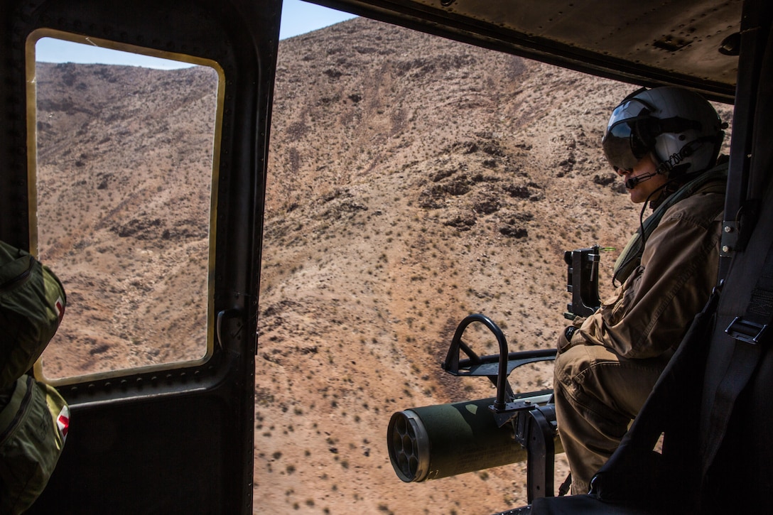 Lance Cpl. Justin Fry, a crew chief with Marine Light Attack Helicopter Squadron (HMLA) 267 “Stingers” and a Van Vleck, Texas, native, scans the terrain from a UH-1Y Huey while it performs tactical maneuvers aboard Marine Corps Air Ground Combat Center Twentynine Palms, Calif., June 10. Marines with HMLA-267 supported Marines with 3rd Battalion, 7th Marine Regiment, during a close-air-support training mission aboard the combat center. (U.S. Marine Corps photo by Sgt. Lillian Stephens/Released)