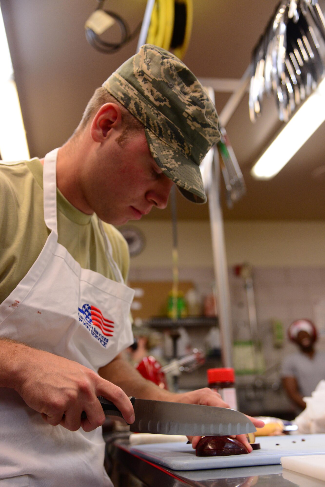Airman 1st Class Tim Jones, assigned to the 341st Force Support Squadron missile feeding section, cuts an apple for a meal during the quarterly Warrior Chef Competition June 22, 2016, at Malmstrom Air Force Base, Mont. Airmen were given 60 minutes to prepare a main entrée from scratch using cranberry sauce as a secret ingredient. (U.S. Air Force photo/Airman 1st Class Magen M. Reeves) 