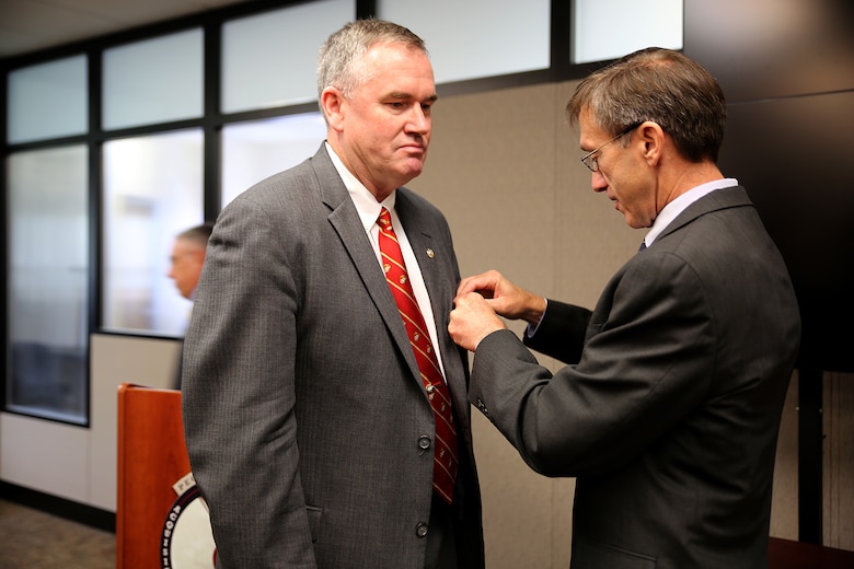 The Honorable Sean Stackley (right), assistant secretary of the Navy for Research, Development and Acquisition, pins a Navy Distinguished Civilian Service medal on William “Bill” Taylor during a Change of Leadership ceremony June 21 aboard Marine Corps Base Quantico, Virginia. Taylor, Program Executive Officer Land Systems and a member of the Senior Executive Service, has served as the Marine Corps’ only PEO since 2007. Stackley lauded Taylor for taking several “broken” programs and turning them into “model” programs. “The PEO’s programs are strong, and the PEO is strong,” Stackley said. “We wouldn’t have that without this superior individual who wasn’t just there at the beginning, but stayed for a decade.” 