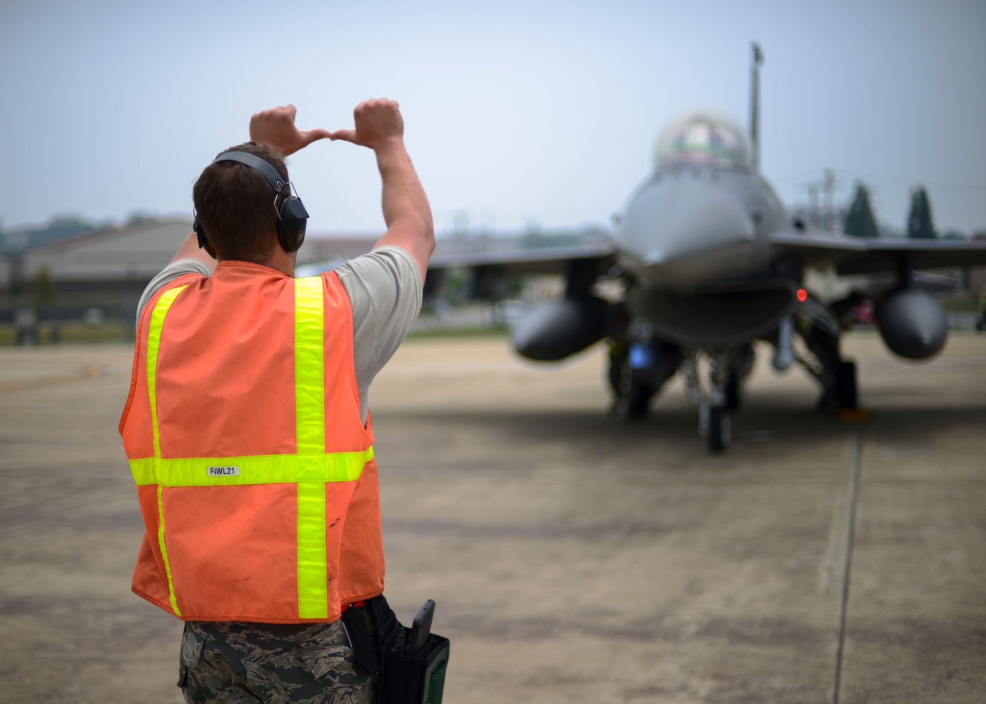 Tech. Sgt. Adam Skadsberg, 148th Aircraft Maintenance Unit weapons one-man, signals to an F-16 Fighting Falcon pilot, June 21, 2016, at Osan Air Base, Republic of Korea. Skadsberg was part of a three-man crew performing the inspection, and was responsible for communicating with the pilots while his teammates inspected each aircraft. (U.S. Air Force photo by Senior Airman Victor J. Caputo/Released)