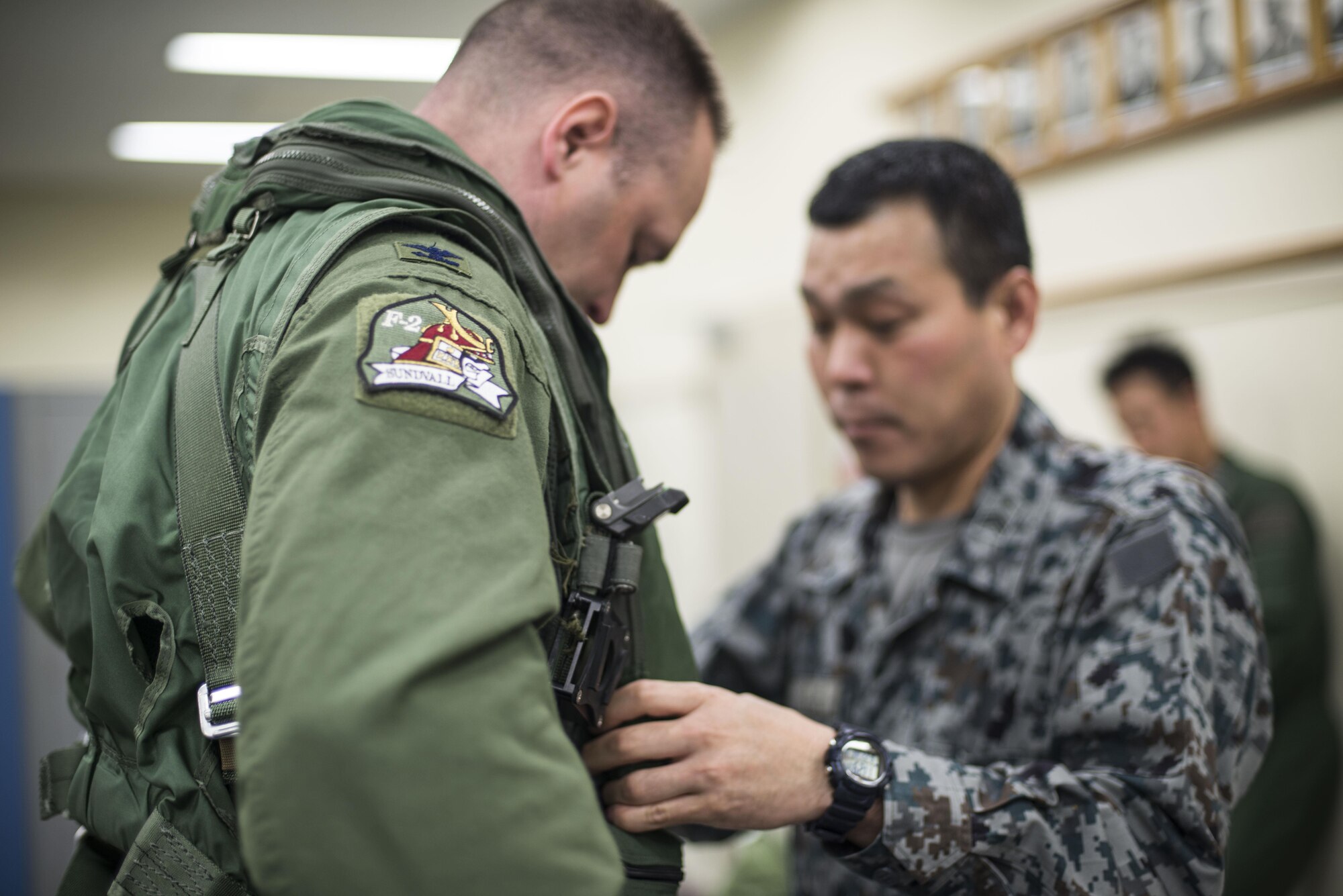 Japan Air Self-Defense Force Master Sgt. Hideya Oyama, the life support superintendent with the 3rd Fighter Squadron, adjusts U.S. Air Force Col. Timothy Sundvall’s (left), the commander of the 35th Fighter Wing, life support vest at Misawa Air Base, Japan, June 22, 2016. Sundvall was invited to fly in an F-2A with the 3rd FS, marking his first time flying in the aircraft. (U.S. Air Force photo by Senior Airman Brittany A. Chase)