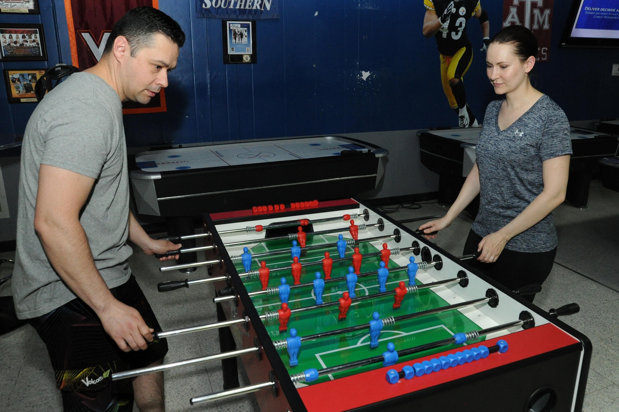 Tech Sgt. Holly Flores and Senior Airman Joseph Flores, members of the 386th Expeditionary Communications Squadron, play foosball at an undisclosed location in Southwest Asia, June 14, 2016. These Airmen are a military couple and were able to deploy together in support of Operation INHERENT RESOLVE. Holly volunteered after her husband was tasked to deploy by their home unit. (U.S. Air Force photo by Senior Airman Zachary Kee)