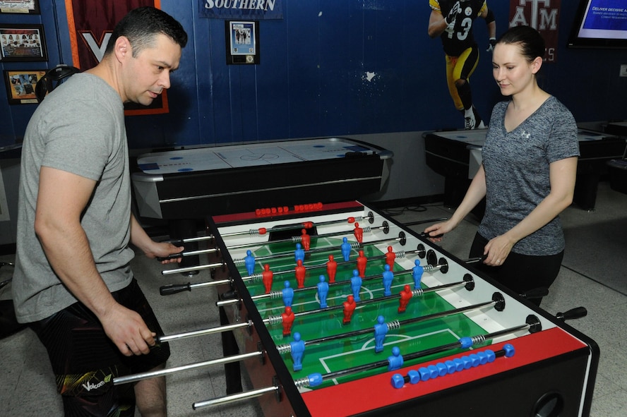 Tech Sgt. Holly Flores and Senior Airman Joseph Flores, members of the 386th Expeditionary Communications Squadron, play foosball at an undisclosed location in Southwest Asia, June 14, 2016. These Airmen are a military couple and were able to deploy together in support of Operation INHERENT RESOLVE. Holly volunteered after her husband was tasked to deploy by their home unit. (U.S. Air Force photo by Senior Airman Zachary Kee)