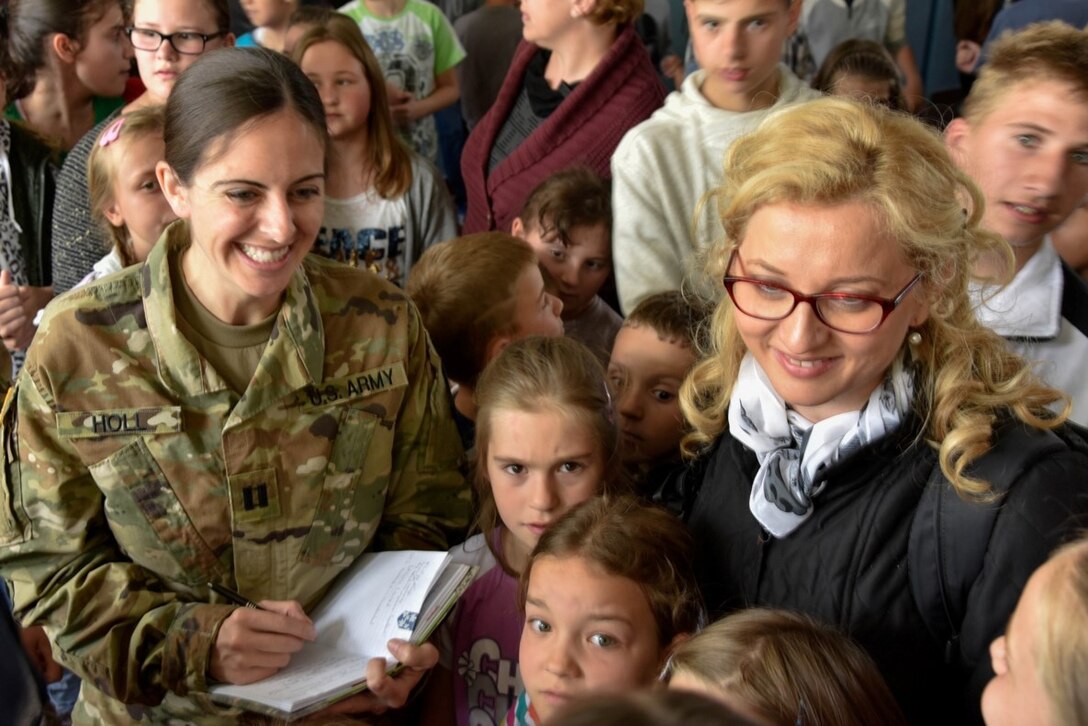 Capt. Lauren Holl, left, assigned to Company A, 457th Civil Affairs Battalion, talks with Bosnia and Herzegovina students during a school visit May 24, 2016. The CA team was following up and assessing the three-year-old renovation of the school that was accomplished by a partnership between the U.S. and the people of Bosnia and Herzegovina. 