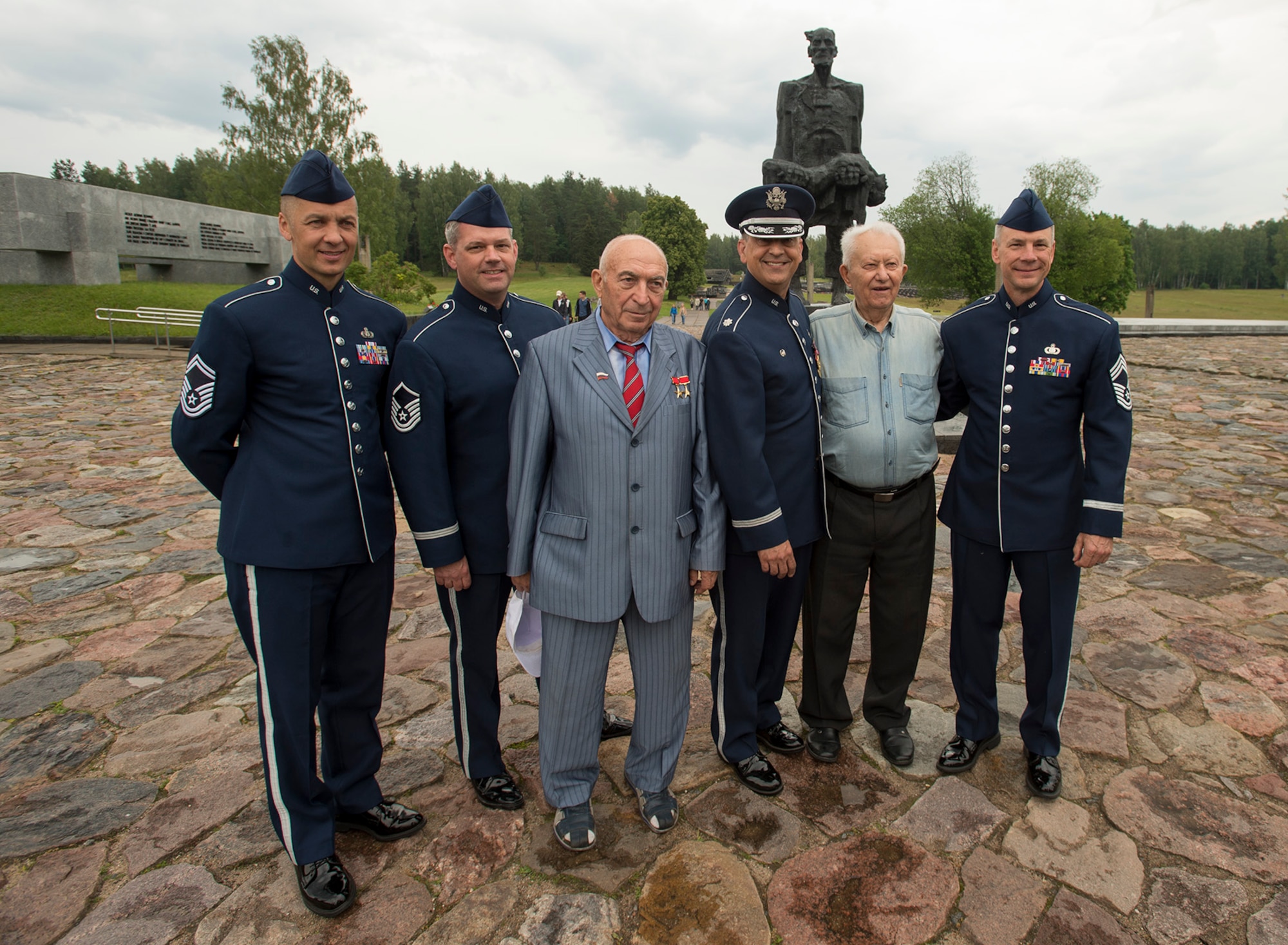 From left, U.S. Air Force Senior Master Sgt. Vladimir Tchekan, U.S. Air Forces in Europe Band’s trombone player; U.S. Air Force Master Sgt. Dave Dell, USAFE Band trumpet player; Vladimir Yarygin, former submariner for the Soviet Union; Lt. Col. Mike Mench, USAFE Band commander; Grigory, former Air Force wing commander for the Soviet Union; and Chief Master Sgt. Mark Burditt, USAFE Band chief enlisted manager, stand for a photograph in front of the “Unbowed Man” statue June 20, 2016, in Khatyn Memorial, Belarus. (U.S. Air Force photo/Technical Sgt. Paul Villanueva II)