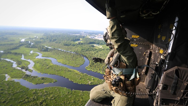 Staff Sgt. Stephen Ferguson, a crew chief with Marine Light Attack Helicopter Squadron 167, 2nd Marine Aircraft Wing, rides in the back of a UH-1Y Venom as it approaches a landing zone during a training exercise near Maine Corps Base Camp Lejeune, N.C., June 17, 2016. Familiarization flights familiarize pilots new to the unit with the different landing zones and flight procedures around the Camp Lejeune area.  