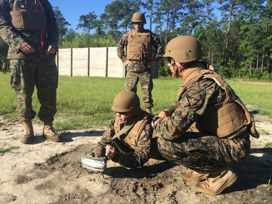 On June 9, 2016 Second Lieutenant Troy Searcy (front center) along with students attached to Combat Engineer Officer course 5-16 (CEO 5-16) emplace a M18A1 Claymore Mine to be detonated on a training range aboard Marine Corps Engineer School, Camp Lejeune, N.C. Claymore mines are used for protection and as protective obstacles in defensive positions. From left to right are Second Lieutenants Troy Searcy, Brock Yackey (back center), and Thomas Cofer.  
