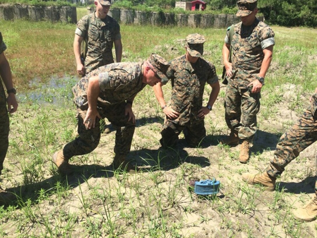 On June 8, 2016 Gunnery Sergeant Douglas Cullins (front left), an instructor with Combat Engineer Instruction Company; instructs students attached to Combat Engineer Officer course 5-16 (CEO 5-16) about the M18A1 Claymore Mine. Claymore mines are a command detonated, directional explosive mine frequently employed by combat engineers. From left to right are Gunnery Sergeant Douglas Cullins, and Second Lieutenants Troy Searcy, Thomas Cofer, and Brock Yackey. 

