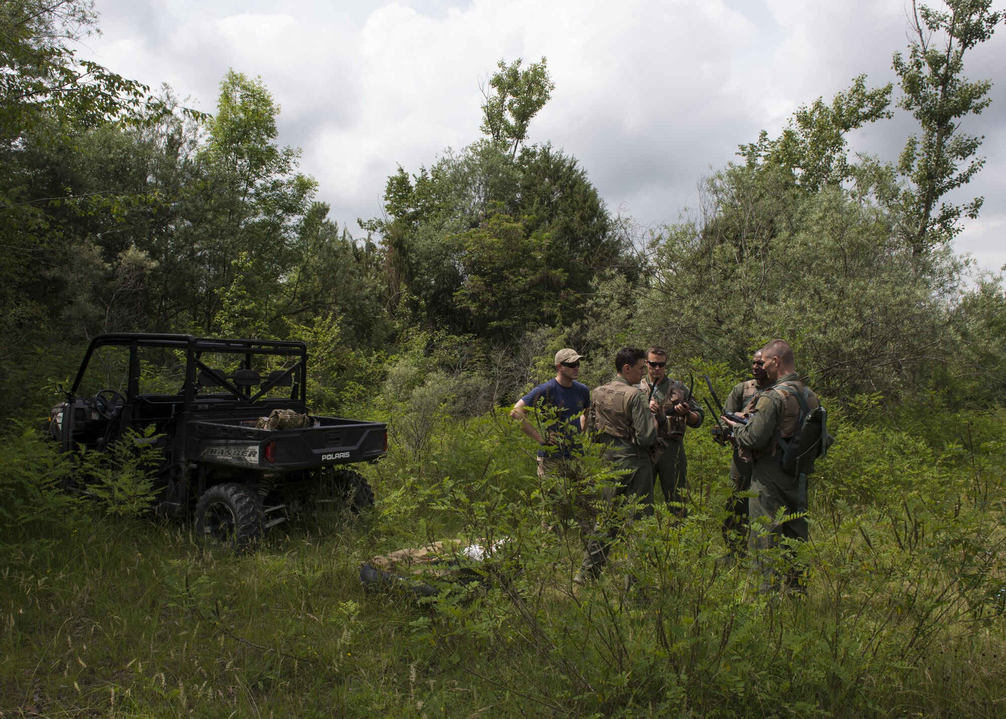 Tech. Sgt. H Jett, 31st Operations Support Squadron NCO in charge of survival, evasion, resistance and escape training, shows combat survival refresher training participants how to operate, Spilimbergo, Italy, June 14, 2016. The students transported the equipment they would have with them after ejecting from an F-16, evaded simulated enemies and signaled for rescue personnel. (U.S. Air Force photo by Senior Airman Krystal Ardrey/Released)