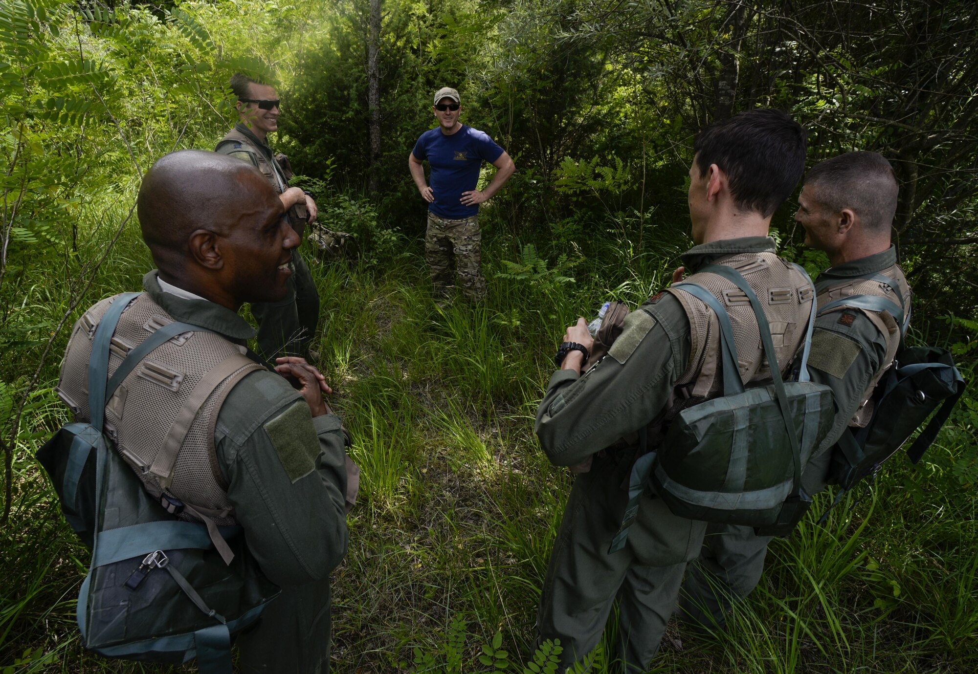 Tech. Sgt. H Jett, 31st Operations Support Squadron NCO in charge of survival, evasion, resistance and escape training, speaks with Airmen during a combat survival refresher training outside of Spilimbergo, Italy, June 14, 2016. The training provided students with a chance practice combat survival procedures. (U.S. Air Force photo by Senior Airman Krystal Ardrey/Released)