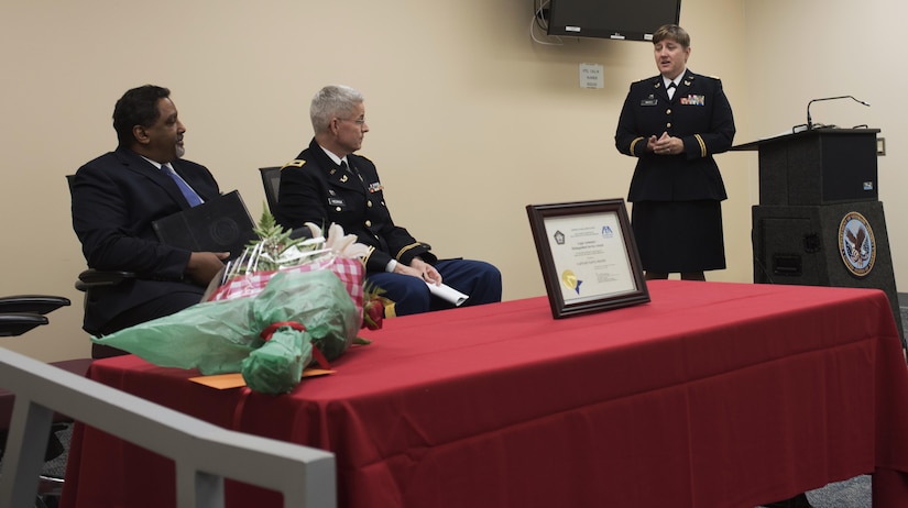 Capt. Tanya Mayes, an administrative law and military justice attorney assigned to the 80th Training Command, addresses the audience during a ceremony where she received the 2015 American Bar Association’s Legal Assistance for Military Personnel Distinguished Service Award. Retired Navy Captain Dwain Alexander, (seated left) a member of the ABA LAMP committee, presented Mayes with the award at the Hunter Holmes McGuire VA Medical Center June 10, 2016. Mayes was recognized for leading an effort to establish a free legal assistance clinic for military veterans after she learned that a significant number of patients needed assistance. Seated next to Alexander is Col. Christopher Headrick, the 80th Training Command’s Staff Judge Advocate.