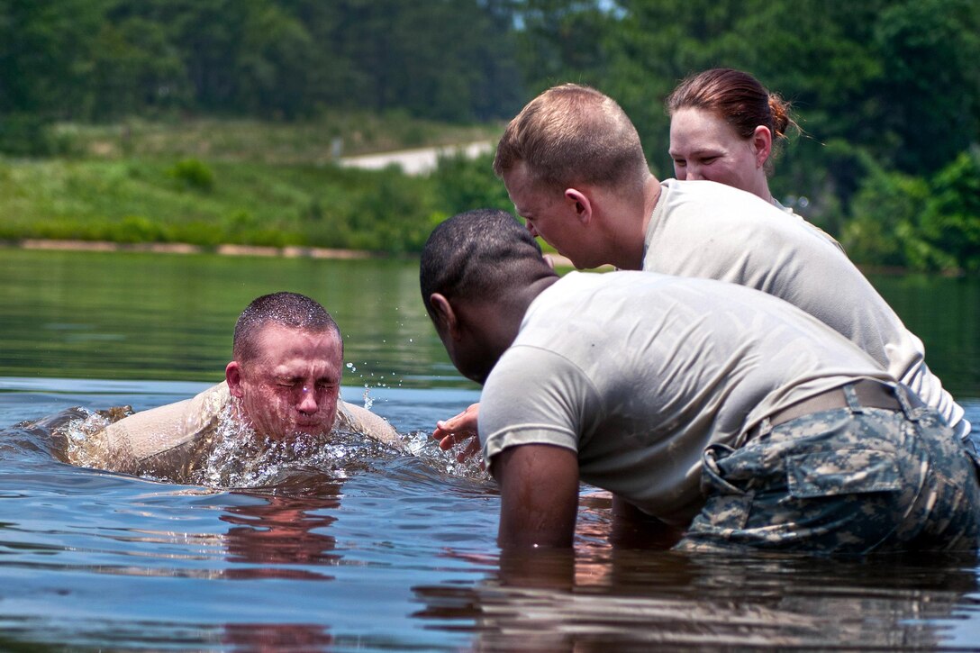 A soldier surfaces after securing a water pump for a tactical water purification system during the annual Quartermaster Liquid Logistics Exercise at Fort Bragg, N.C., June 14, 2016. Army photo by Staff Sgt. Dalton Smith