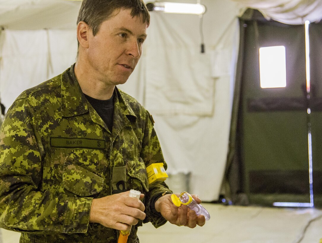 Canadian Navy Lt. Eric Baker, pharmacist, Garrison Pediwawa, Ottawa, Canada discusses the importance of medication with a role player at the 325th Combat Support Hospital during Combat Support Training Exercise 91-16-02, Fort Hunter Liggett, Calif., June 18, 2016. As the largest U.S. Army Reserve training exercise, CSTX 91-16-02 provides Soldiers with unique opportunities to sharpen their technical and tactical skills in combat-like conditions. (U.S. Army photo by Spc. Fatima Konteh, 367th Mobile Public Affairs Detachment)