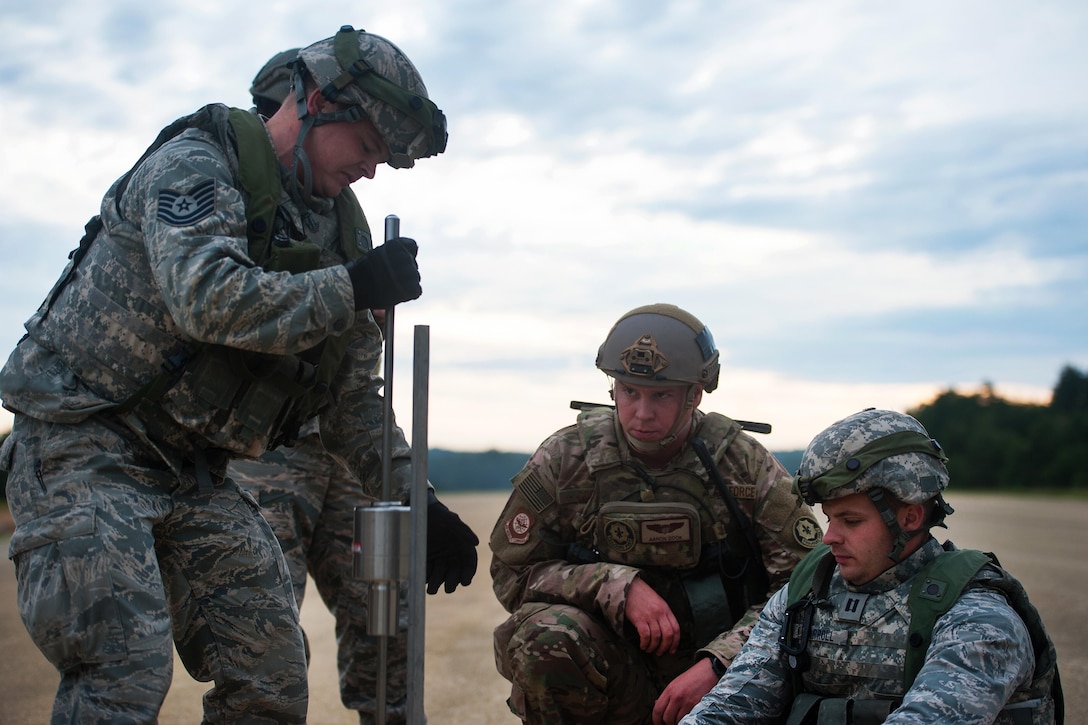 Air Force Maj. Aaron Cook, center, works with airmen during Exercise Swift Response 16 in Hohenfels, Germany, June 16, 2016. Cook is a liaison officer assigned to the 621st Mobility Support Operations Squadron Air Mobility, and the airmen are airfield assessment members assigned to the 821st Contingency Response Group. The exercise, a military crisis response training event for multinational airborne forces, has more than 5,000 participants from 10 NATO nations. Air Force photo by Master Sgt. Joseph Swafford
