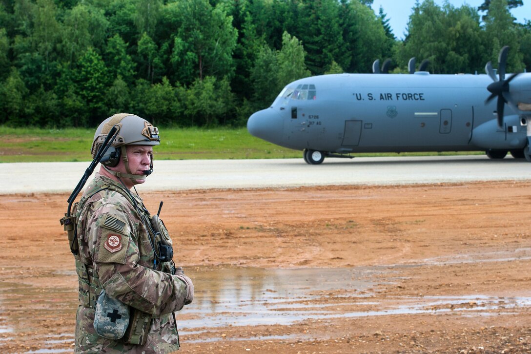 Air Force Maj. Aaron Cook radios a C-130J Super Hercules pilot while the aircraft is being downloaded during Exercise Swift Response 16 in Hohenfels, Germany, June 17, 2016. Cook is a liaison officer assigned to the 621st Mobility Support Operations Squadron Air Mobility. Air Force photo by Master Sgt. Joseph Swafford