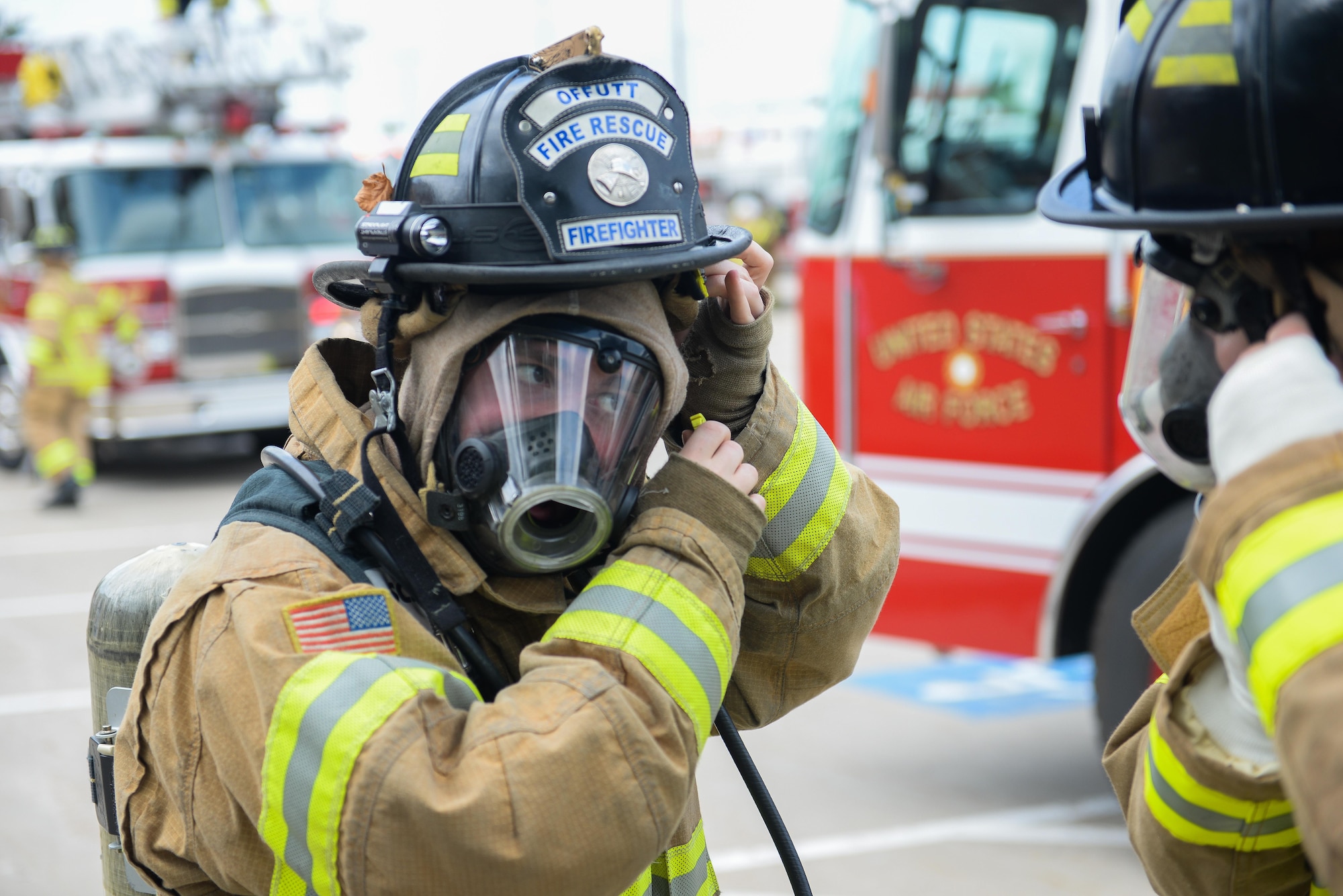 Christopher Paillot, firefighter with the 55th Civil Engineer Squadron, tightens his helmet strap during a structure rescue training exercise at building 382 at Offutt Air Force Base, Neb., June 21, 2016. The exercise was held to strengthen the fire department’s team cohesion and improve mission readiness. (U.S. Air Force photo by Zachary Hada)