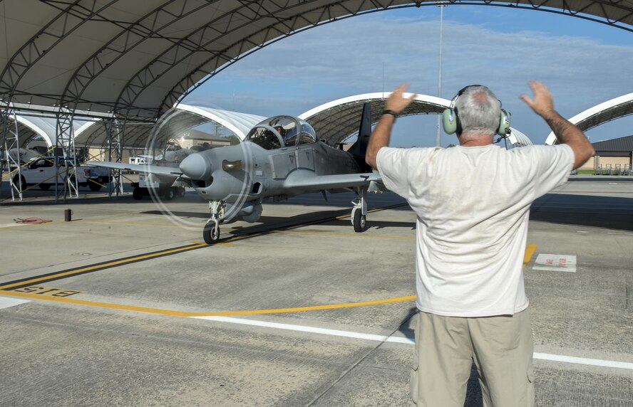 Anthony Hamilton, A-29 Super Tucano crew chief, marshals out U.S. Air force Col. Joseph Locke, 93d Air Ground Operations Wing commander, and a pilot from the 81st Fighter Squadron, before takeoff, June 23, 2016, at Moody Air Force Base, Ga. The 81st FS executes an annual flying program of approximately 3,000 sorties and 4,500 flying hours. (U.S. Air Force photo by Tech. Sgt. Zachary Wolf/Released)