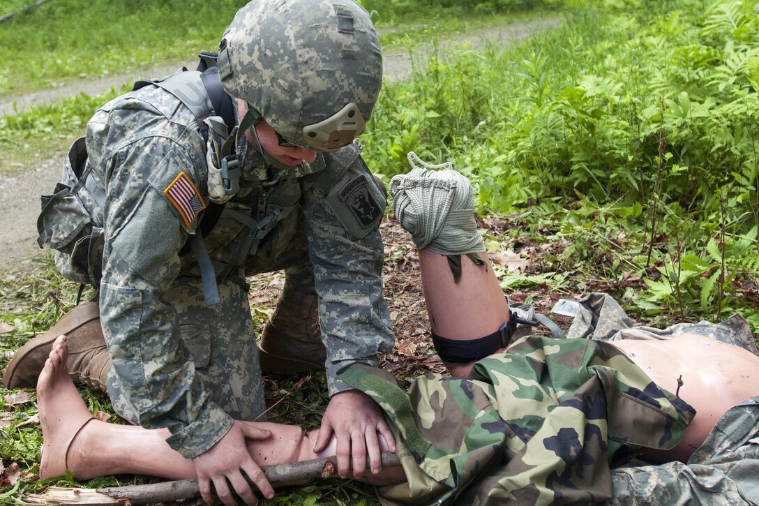 Army Pfc. Tyler Vance sets a training dummy's broken leg during a medical lane exercise at Camp Ethan Allen Training Site in Jericho, Vt., June 14, 2016. Vance is assigned to the Vermont National Guard’s Company B, 3rd Battalion, 172nd Infantry Regiment, 86th Infantry Brigade Combat Team (Mountain). Army National Guard photo by Spc. Avery Cunningham