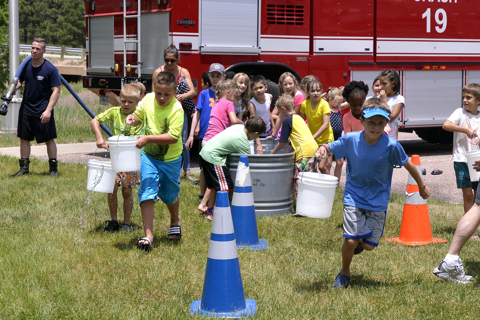 Children compete in the Bucket Brigade, one of many events June 22 at the U.S. Air Force Academy's Youth Fire Safety Camp. The annual camp gives children at the Academy the chance to meet their local firefighters and take part in several educational fire-prevention events. (U.S. Air Force photo/Jason Gutierrez)