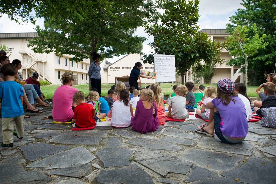 Sandra DeMezzo, a registered dietitian nutritionist with the Health and Wellness Center, reads a book about vegetables to children during a Summer Reading Program event at Hurlburt Field, Fla., June 23, 2016. Week three of the eight-week program focuses on the importance of fruit and vegetable intake as well as physical fitness. (U.S. Air Force photo by Senior Airman Krystal M. Garrett)