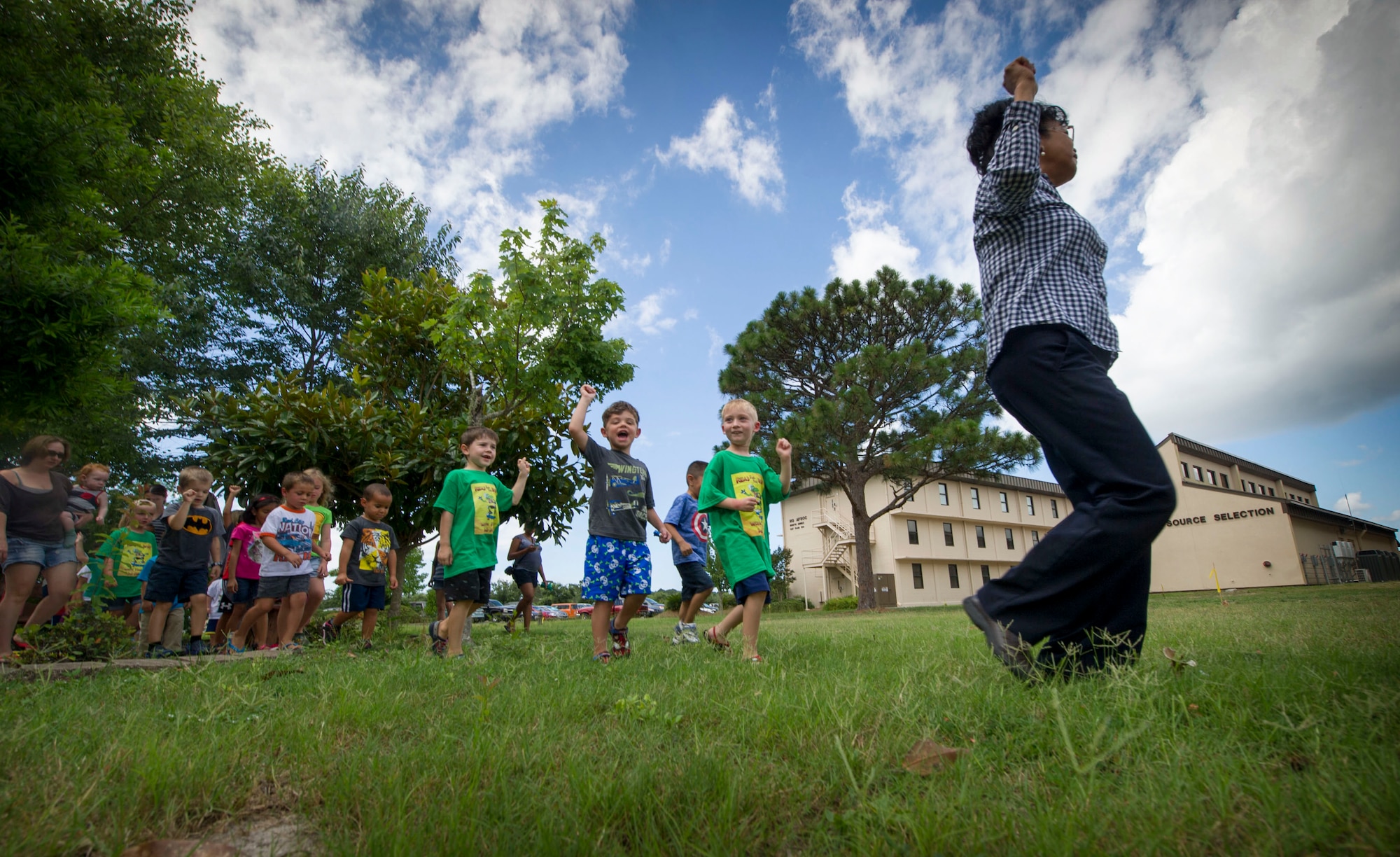 Yolanda Larson, produce manager at the Hurlburt Field commissary, leads children while marching and chanting about fruits and vegetables during a Summer Reading Program event at Hurlburt Field, Fla., June 23, 2016. During the event, children participated in physical activities while learning the importance of fruit and vegetable intake. (U.S. Air Force photo by Senior Airman Krystal M. Garrett)