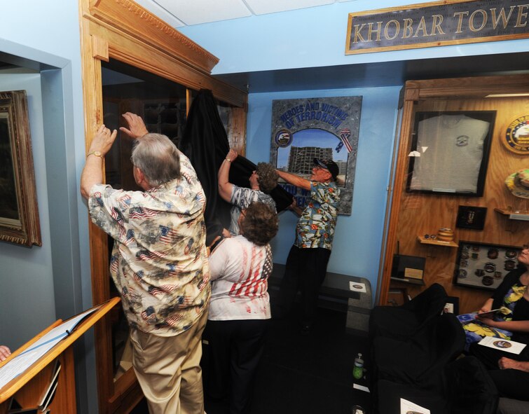 Family members of the fallen Airmen of the Khobar Towers attack of June, 25, 1996, unveil the newest exhibit honoring the 19 Airmen who died during the Khobar Towers Memorial Ceremony, June 23, 2016, Maxwell Air Force Base, Ala. The Air Force Enlisted Heritage Hall personnel held a wreath laying ceremony in honor of the 20th anniversary of the Khobar Towers attack and presented their newest and upgraded display in honor of the Airmen who lost their lives. (U.S. Air Force photo/ Senior Airmen Alexa Culbert)
