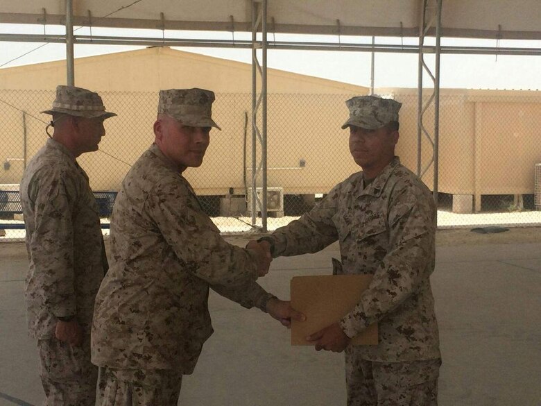 Cpl. Daniel “D.J.” Deleon, right, is presented an award by his father, Maj. James Ramsey, while deployed in Bahrain in June 2015. Throughout their time in the Marine Corps, Ramsey and Deleon found themselves deployed or stationed together multiple times. (Courtesy photo/Released)