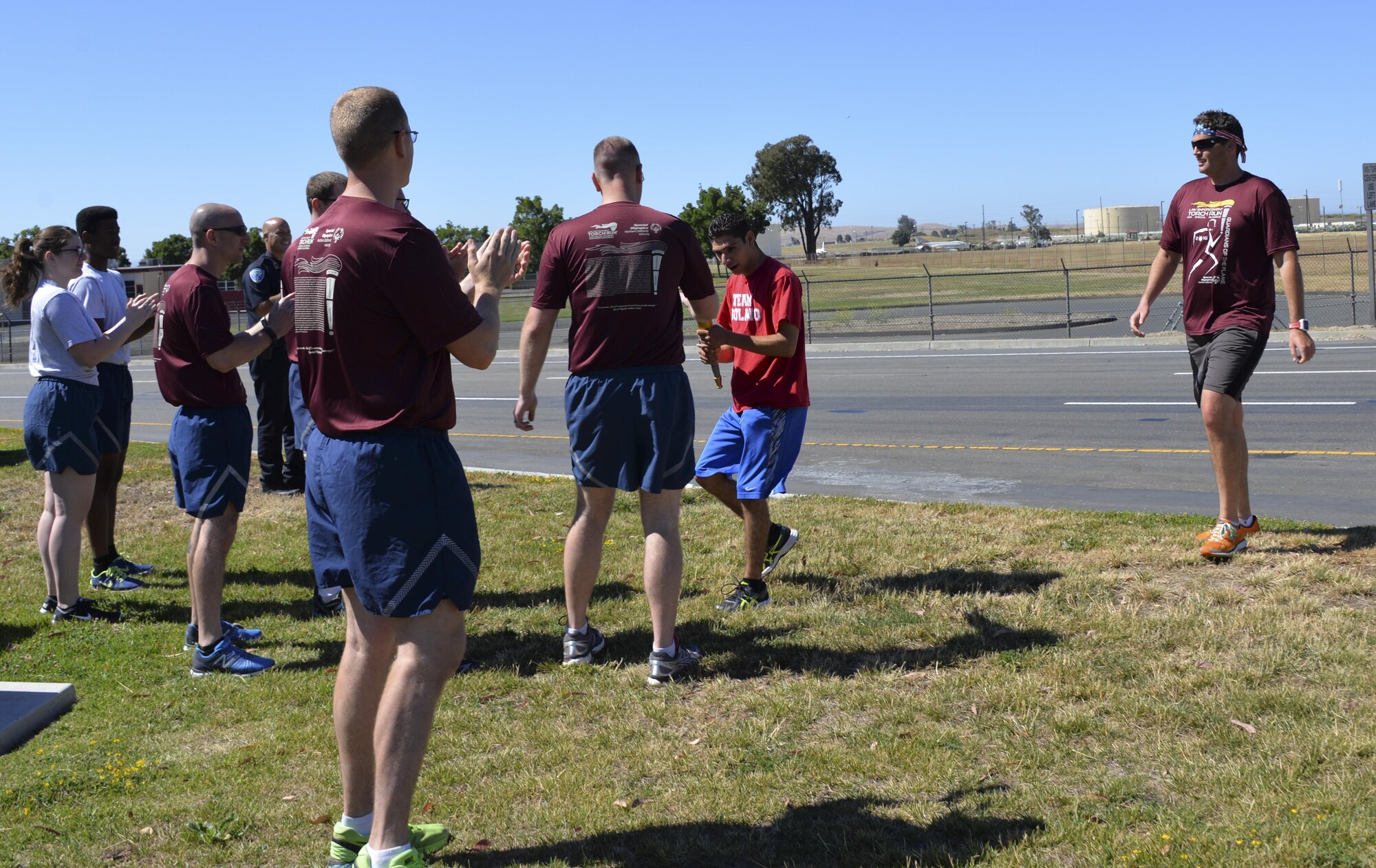 Members from the 60th Security Forces Squadron receive "The Flame of Hope," an olympic torch passed from one law enforcement agency to the next, from the Fairfield Police Department, June 23 at Travis Air Force Base, California. The 60th SFS then ran the torch from the Main gate to the North Gate as part of the Northen California Special Olympics Summer Games at the University of California in Davis, California. 
