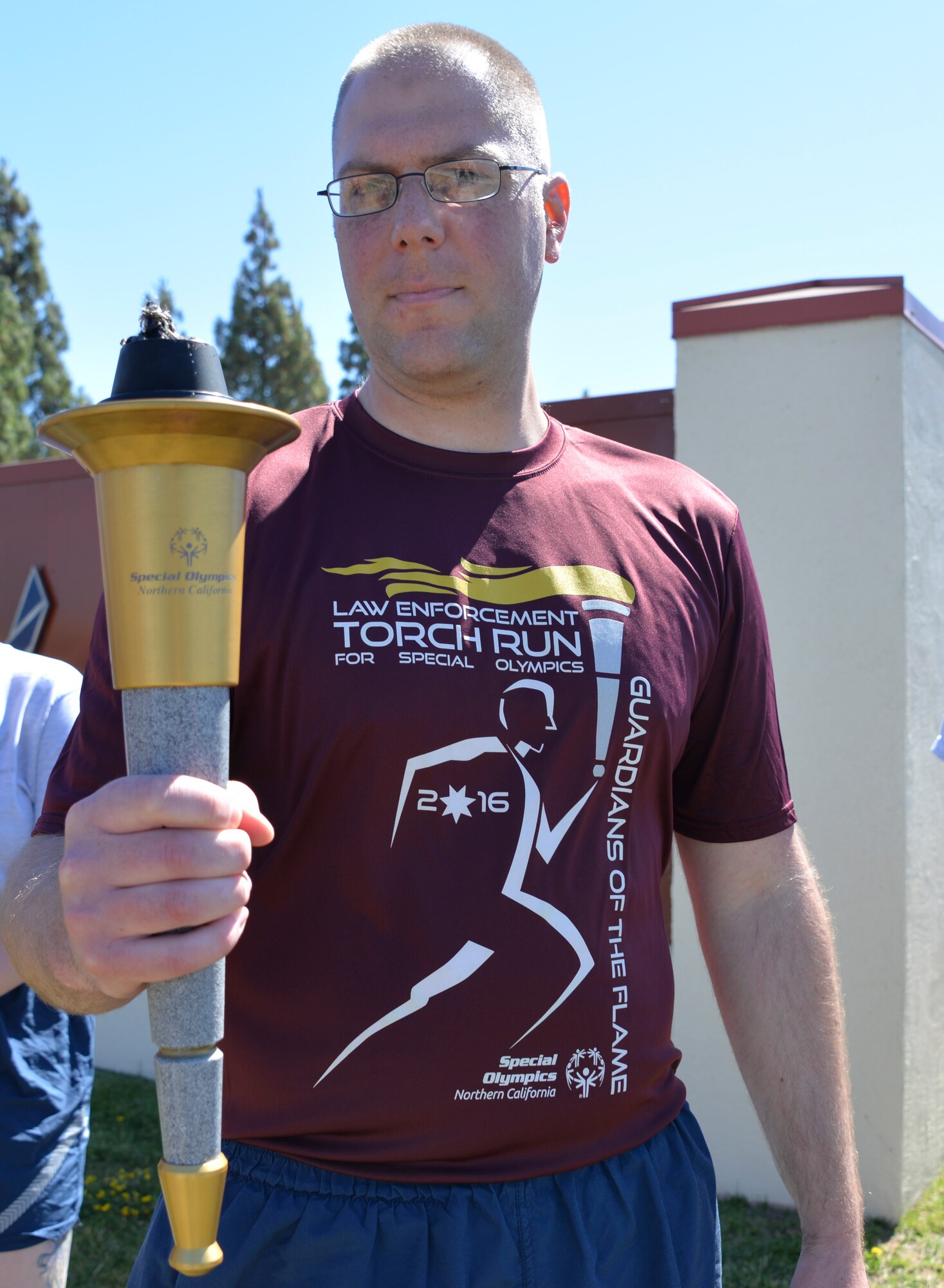 Staff Sgt. Steven Sawyer, 60th Security Forces Squadron police services NCO in charge and event participant, receives "The Flame of Hope," an olympic torch passed from one law enforcement agency to the next, from the Fairfield Police Department, June 23 at Travis Air Force Base, California. The 60th SFS then ran the torch from the Main gate to the North Gate as part of the Northen California Special Olympics Summer Games at the University of California in Davis, California. 