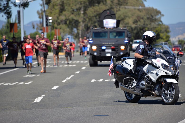 Members from the 60th Security Forces Squadron receive "The Flame of Hope," an olympic torch passed from one law enforcement agency to the next, from the Fairfield Police Department, June 23 at Travis Air Force Base, California. The 60th SFS then ran the torch from the Main gate to the North Gate as part of the Northen California Special Olympics Summer Games opening ceremony at the University of California in Davis, California. 