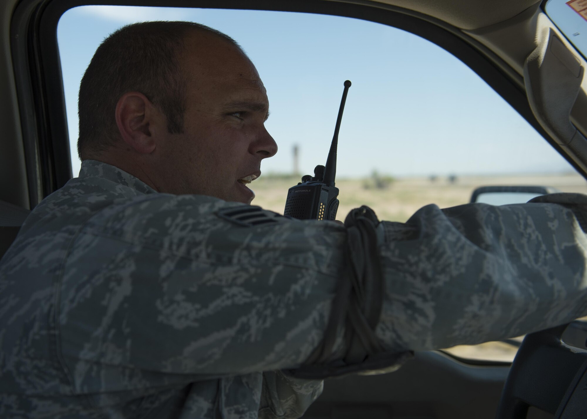 Staff Sgt. Kenneth, a 49th Maintenance Squadron line delivery crew chief, calls Holloman’s air traffic control tower for permission to cross a part of the flight line. Line delivery crew chiefs ensure the safe and timely delivery of munition assets to the flight line in support of the 49th Wing and tenant unit flying missions. (Last names are withheld due to operational requirements. U.S. Air Force photo by Senior Airman BreeAnn Sachs)