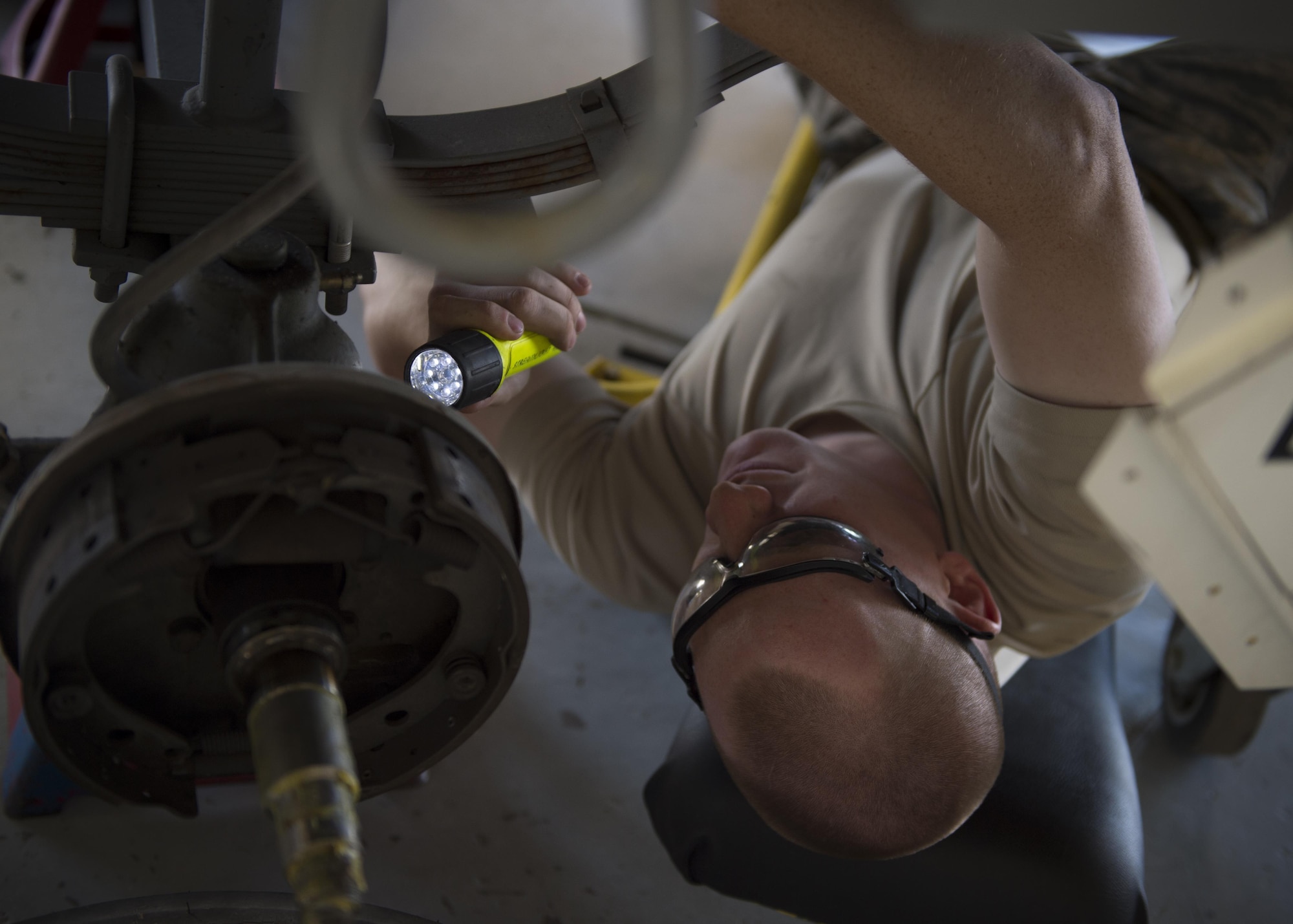 Senior Airman Joe, a 49th Maintenance Squadron munitions crew chief, inspects the bottom of an ammunitions trailer during a 720-day inspection at Holloman. During the inspection, crew chiefs disassembled and checked every aspect of the trailer for any cracks, breaks, missing parts and damages. (Last names are withheld due to operational requirements. U.S. Air Force photo by Senior Airman BreeAnn Sachs)
