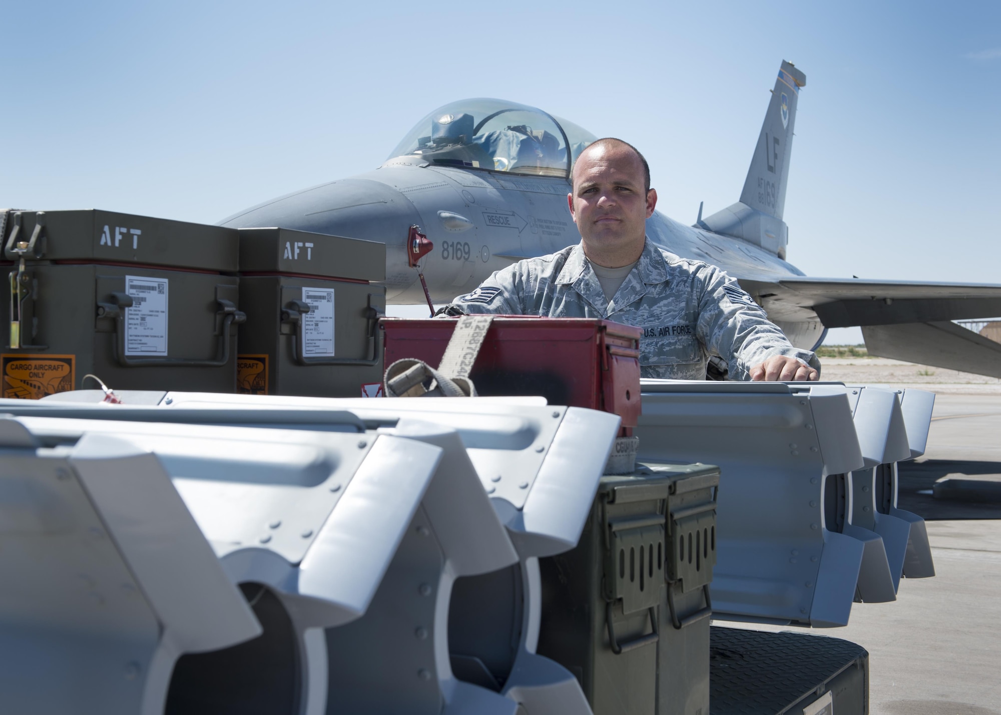Staff Sgt. Kenneth, a 49th Maintenance Squadron line delivery crew chief, stands beside a loaded ammunition trailer waiting to arm an F-16 Fighting Falcon on Holloman. “We are the ones who give the munitions to the people who go and fight,” said Kenneth. “Without our job, those fighter craft are just an expensive airline.” (Last names are withheld due to operational requirements. U.S. Air Force photo by Senior Airman BreeAnn Sachs)