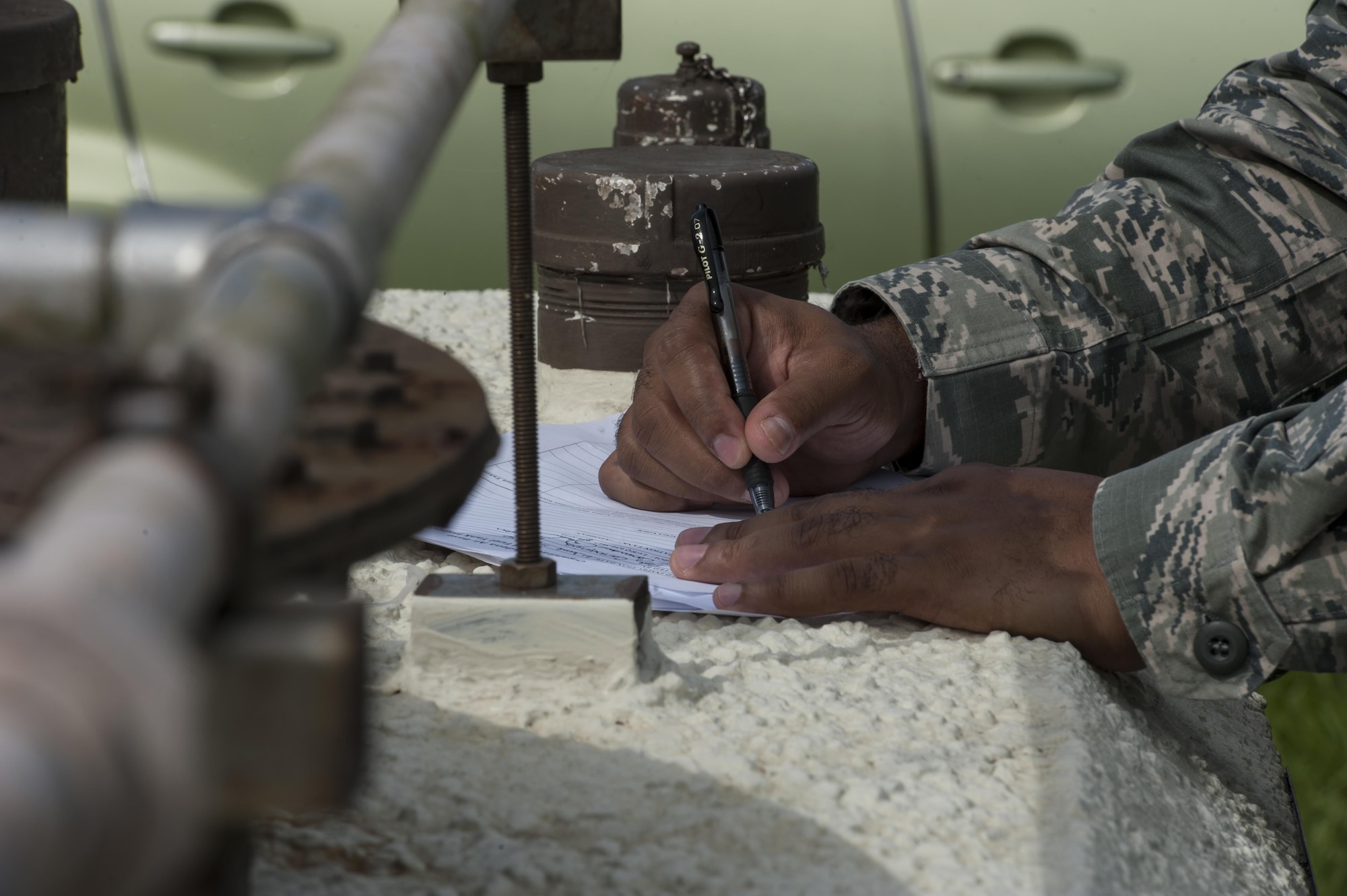U.S. Air Force Tech. Sgt. Camarius Johnson, 18th Logistics Readiness Squadron fuels quality assurance evaluator, completes an organizational tank inspection June 21, 2016, at Kadena Air Base, Japan. Part of the inspection process involves getting paperwork signed by the evaluators. (U.S. Air Force photo by Airman 1st Class Lynette M. Rolen)