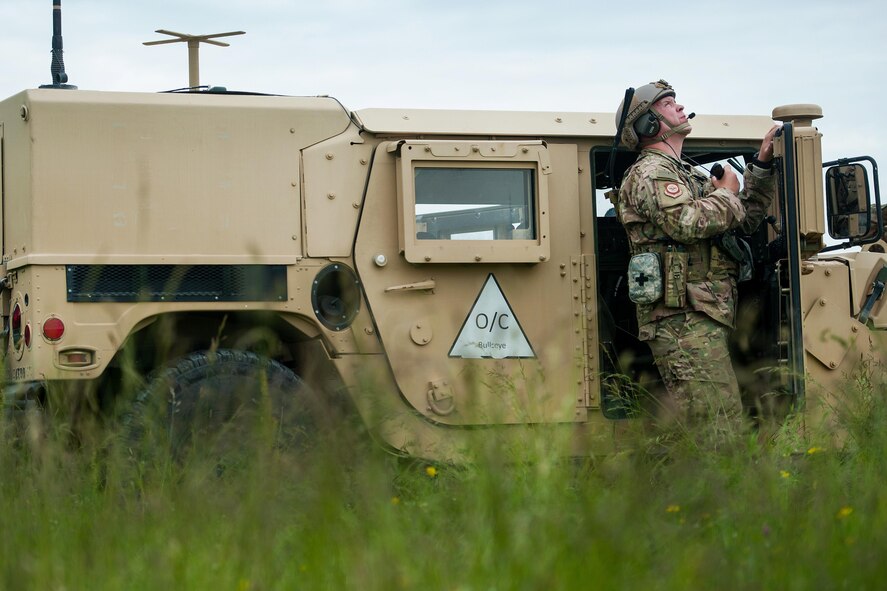 Air Force Maj. Aaron Cook watches a C-130J aircraft fly over his position during Exercise Swift Response 16 in Hohenfels, Germany, June 16, 2016. Cook is a liaison officer assigned to the 621st Mobility Support Operations Squadron Air Mobility. Air Force photo by Master Sgt. Joseph Swafford