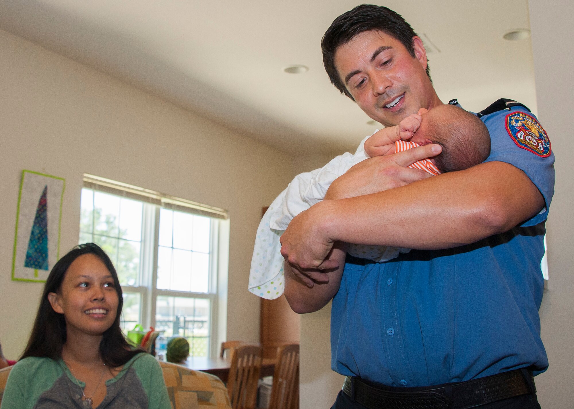 Timothy Panzer, 96th Civil Engineer Group fire captain, holds the baby he helped deliver while Mom, Leana Zimmerman, looks on June 20 at Eglin Air Force Base, Fla. Panzer, along with Kyle Vaughn, Mark Merrill and Walter Carney, also 96th CEG firefighters, helped deliver Luca Zimmerman, in base housing after responding to a 911 call. (U.S. Air Force photo/Ilka Cole)