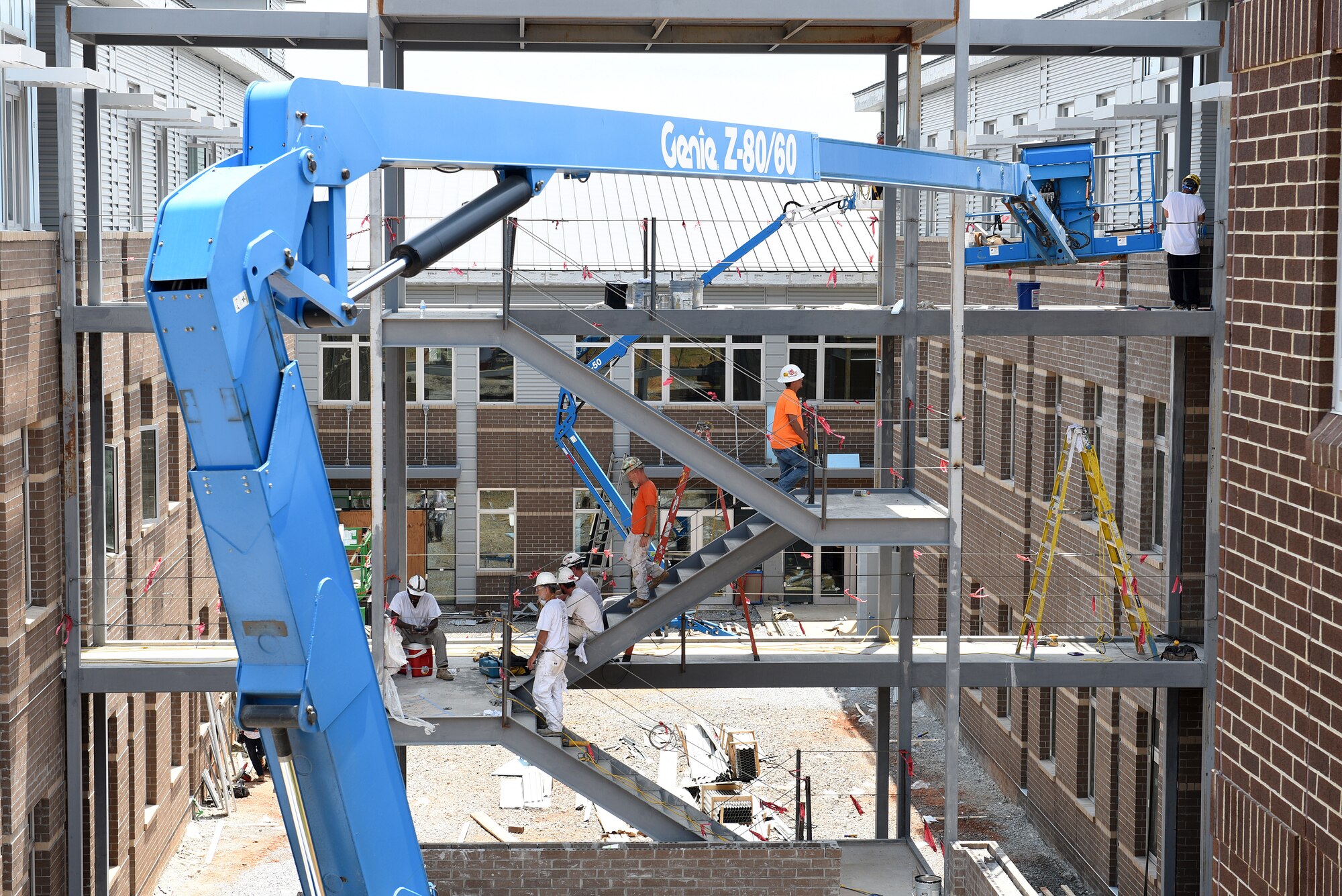 Workers ascend and descend the breezeway staircase structure between the two dormitory buildings under construction, June 23, 2016 at the I.G. Brown Training and Education Center in Louisville, Tenn. Ladders and lifts (six in all) add to the building site's complexity, with the inner courtyard, and further still, the classroom building in the background. The facility will contain approximately 47,000 square feet of additional space on three levels and two levels with ten 20-person and two 100-person classrooms. (U.S. Air National Guard photo by Master Sgt. Mike R. Smith/Released)